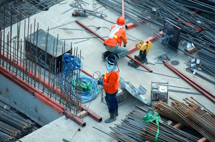 Ouvriers en tenue orange sur un chantier de béton armé